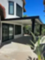 Black metal patio cover added to house