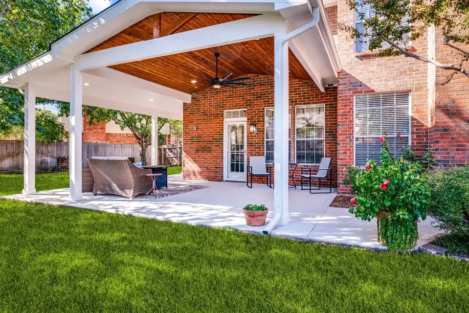 Covered patio with brick wall, seating, and ceiling fan
