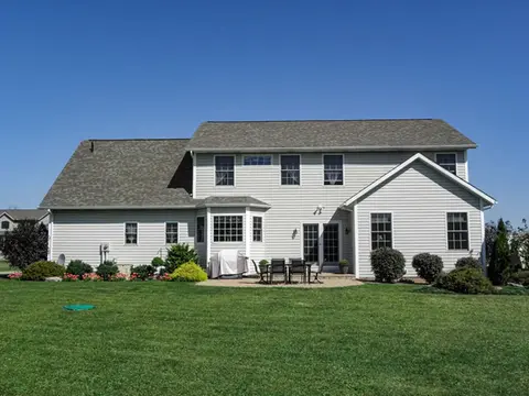 Gray two-story house with patio and yard