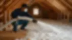 Technician installing modern home insulation in an attic to improve HVAC efficiency and year-round home comfort.