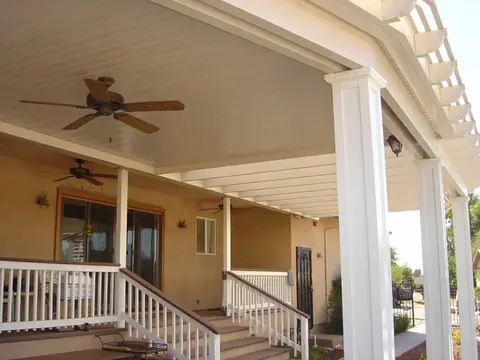 Covered patio with ceiling fan, white columns, and steps