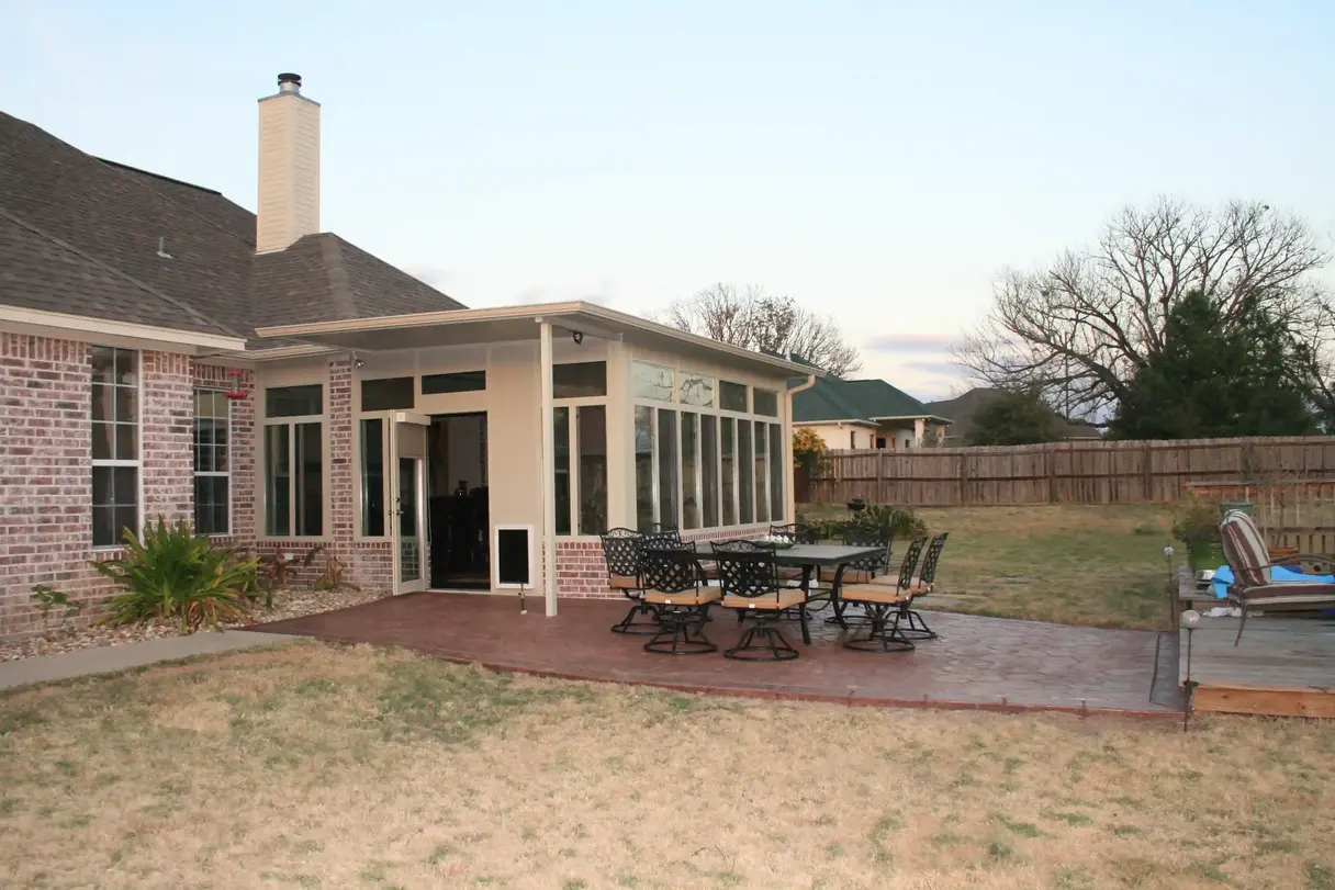 Brick home's sunroom addition with patio furniture