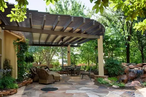 Covered patio with seating area and landscaping