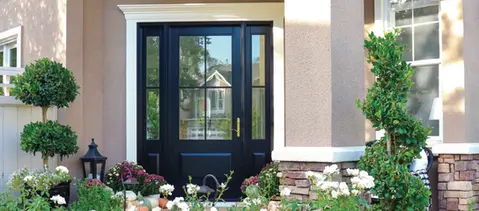 Black front door with sidelights, fall flowers