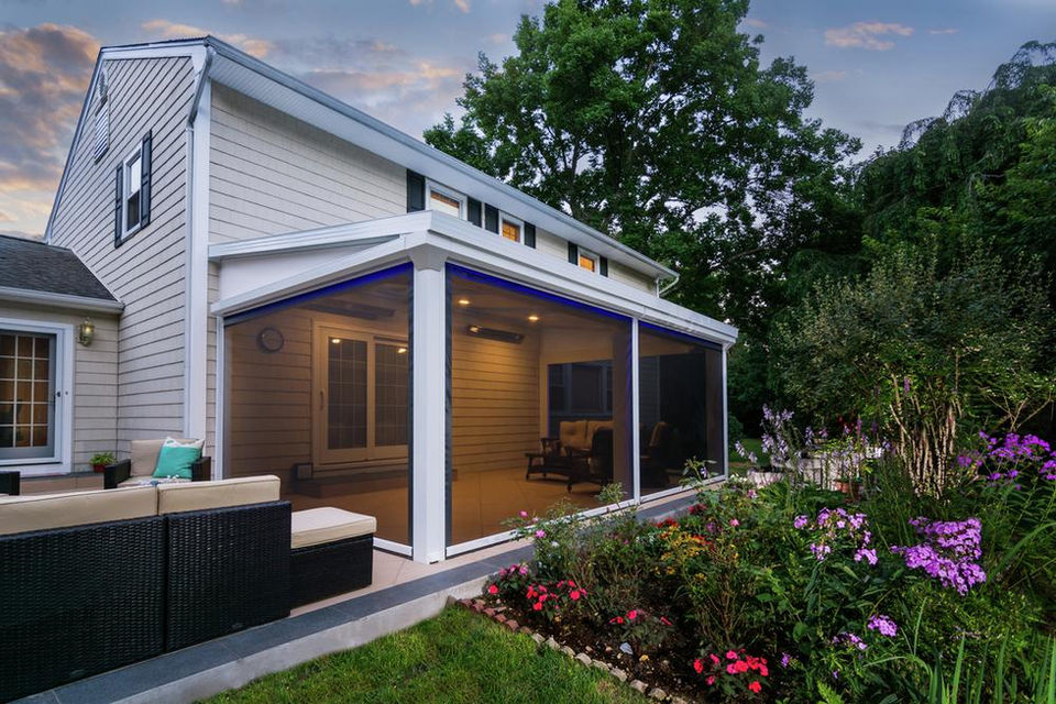 Screened-in patio addition with furniture and lush garden