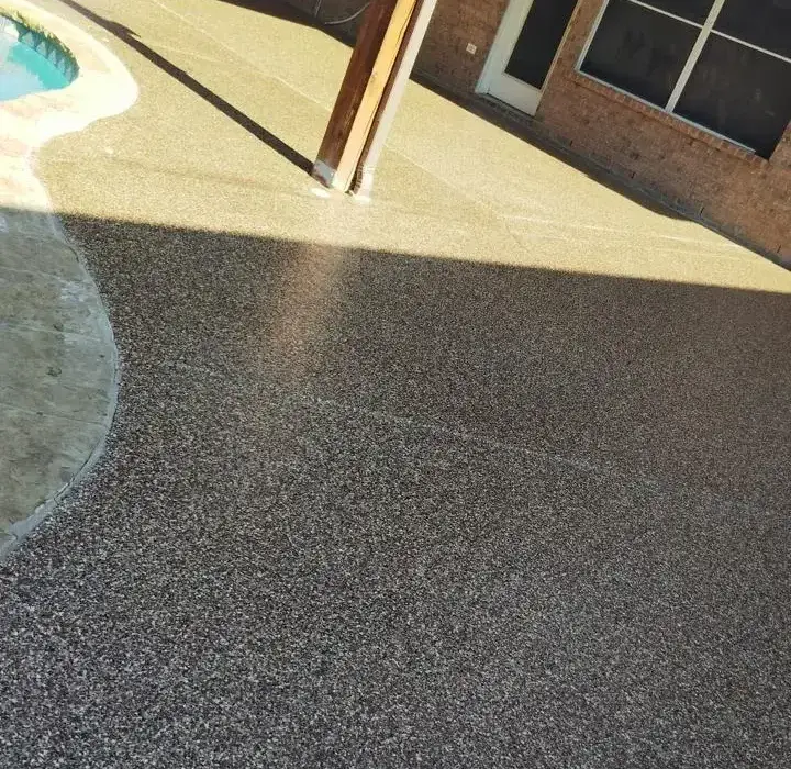 New pool deck with exposed aggregate finish, adjacent to house