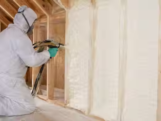 Professional technician installing modern home insulation to improve energy efficiency and indoor comfort.