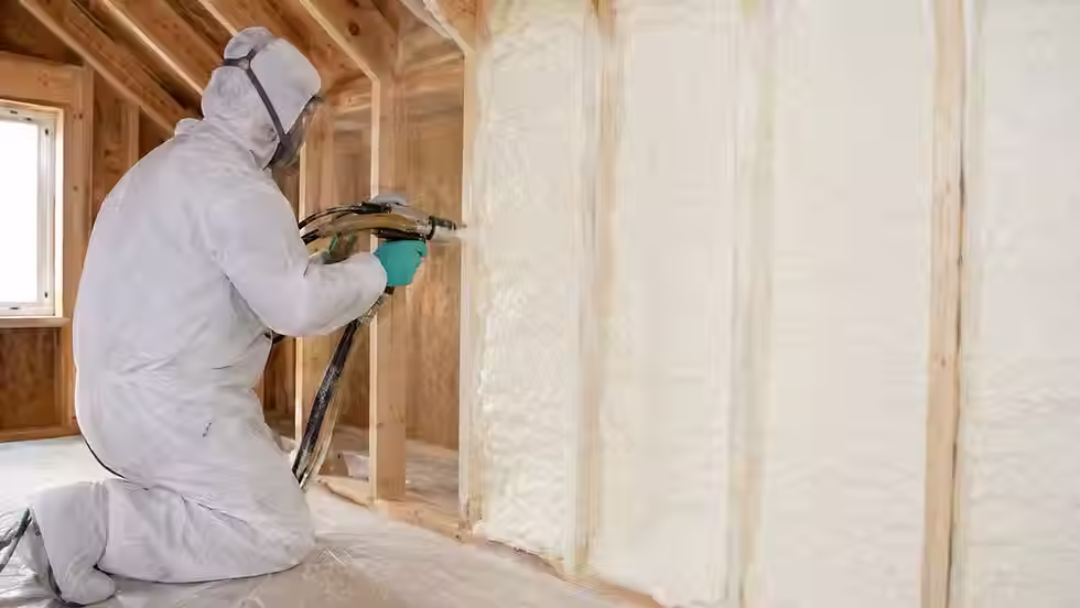 Professional technician installing modern home insulation to improve energy efficiency and indoor comfort.