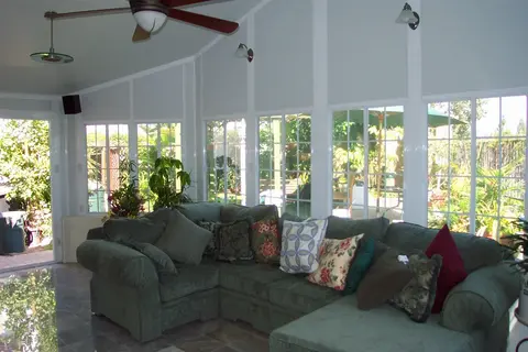 Sunroom addition with sectional sofa and large windows