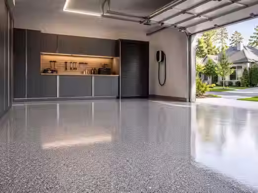 Modern garage with durable concrete floor coating in mid-grey finish with flake texture and clean lighting