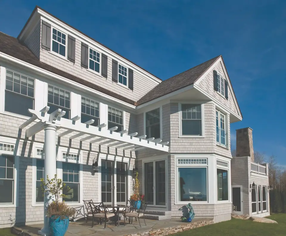 Large gray house with white trim and pergola