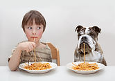 Jongen en hond eten Pasta