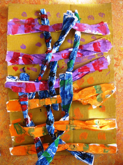 Colorful children's art project with woven paper strips on vibrant background