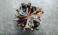 Top view of a diverse team of people joining hands in a collaborative and inclusive busine