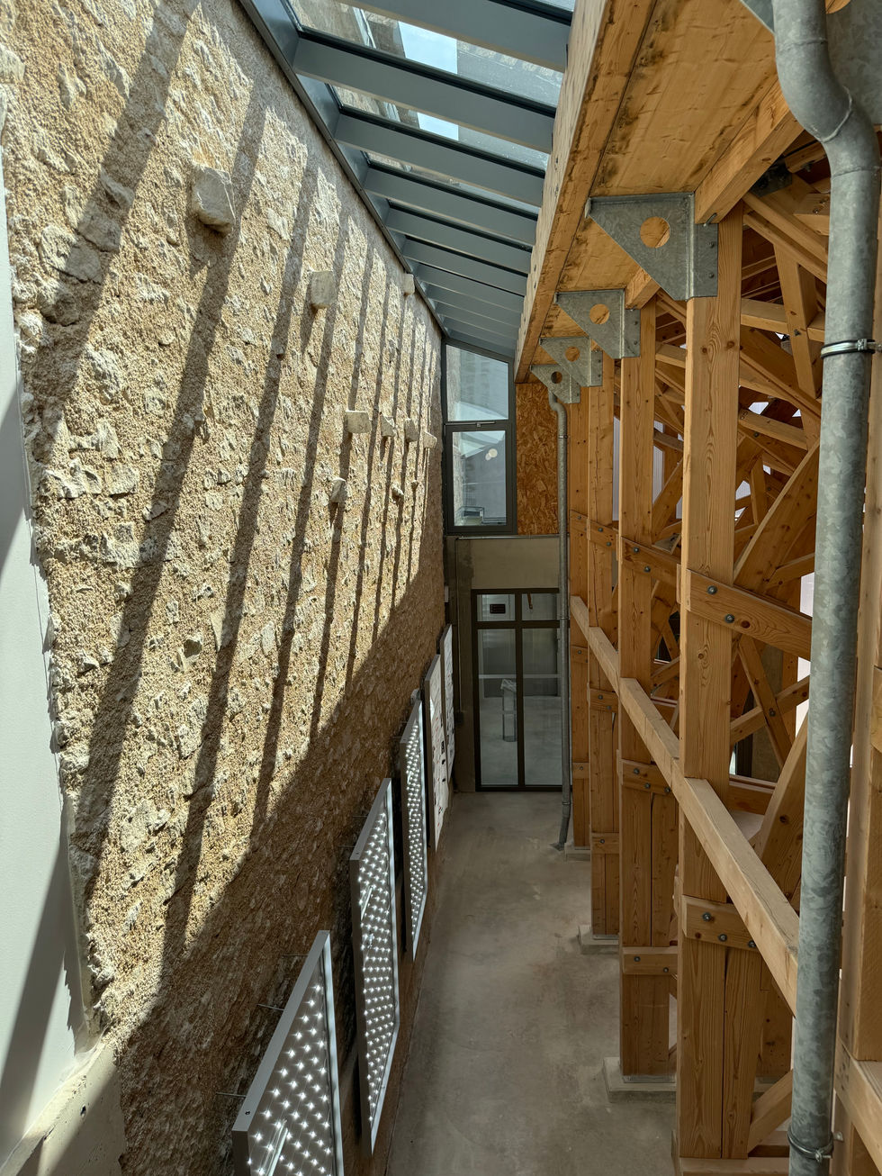 Le mur d'enceinte intégré dans la halle et mis en valeur par une verrière