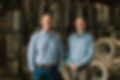 Photo of Mark Yates and Scott Yates, owners of Eastern Wire Products. They are standing in front of automatic baler wire, single and double loop bale ties