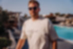 Ben Bowns in Glorious Santorini Greece, casually posing with our new oversized fashion T-shirt in front of the swimming pool