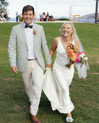 Bride in a bespoke wedding dress walking with groom