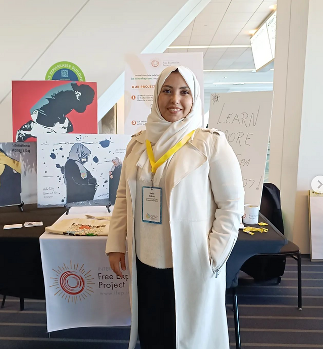 Haifa Subay in front of her art
