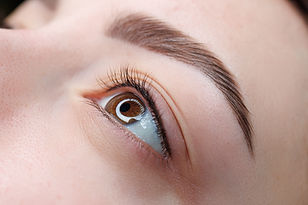 A close-up of the girl's eyes with permanent makeup between the eyelashes is the finished
