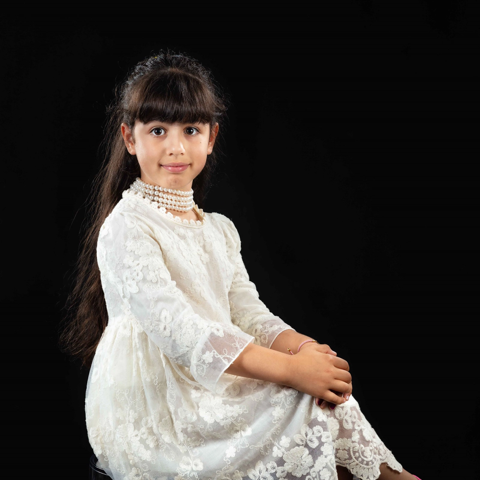 Kinder Fotoshooting Düsseldorf – Mädchen in elegantem weißen Kleid auf schwarzem Hintergrund. Klassisches Porträt im Fotostudio.