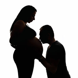 Künstlerische Babybauchfotos Düsseldorf – Silhouettenaufnahme mit Kind küsst den Bauch