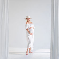 Babybauch-Fotoshooting in Düsseldorf – Schwangere Frau in weißem Kleid mit natürlichem Licht im Studio