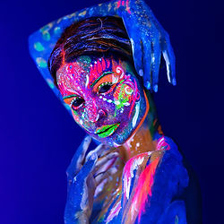 Frau mit buntem UV-Bodypainting im Gesicht bei UV Fotografie Düsseldorf