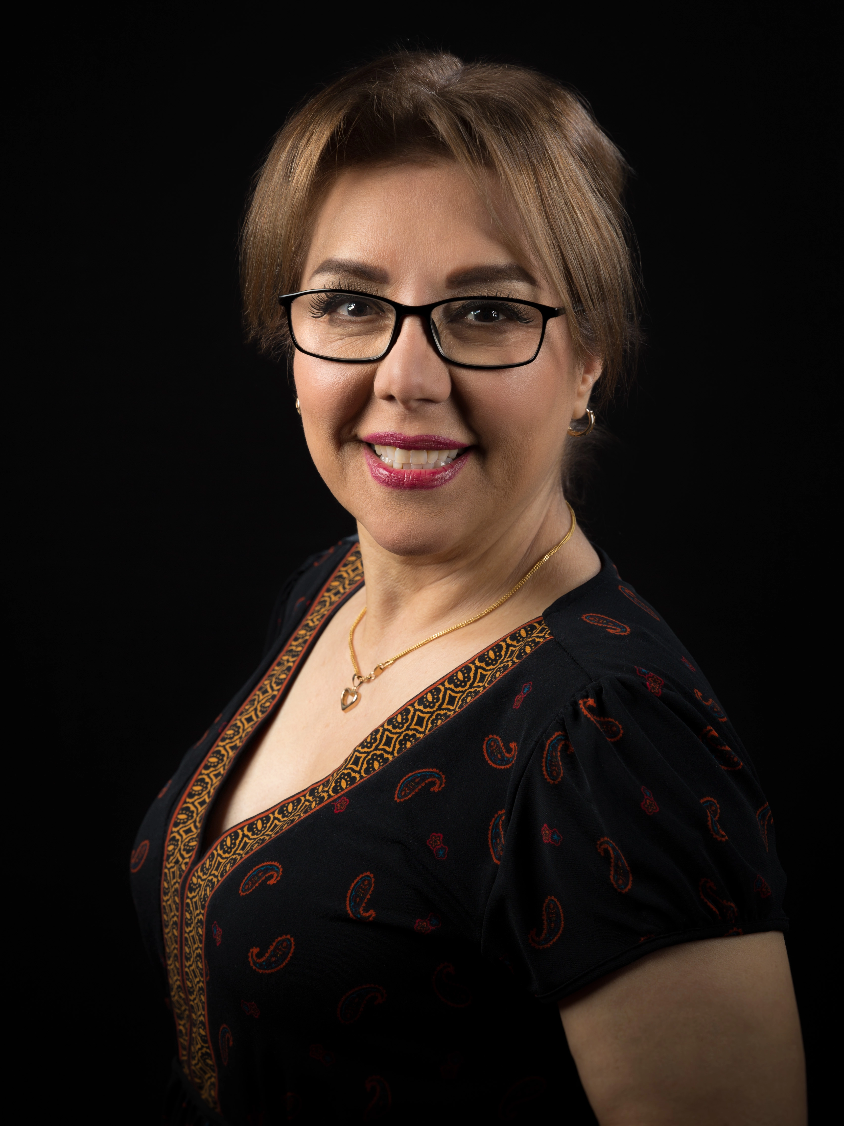 Nahaufnahme einer lächelnden Frau mit Brille – Studio-Portrait auf schwarzem Hintergrund
