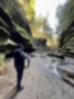 A dad and his young daughter stop to stare at the beauty of the rock formations at Hocking Hills State Park on their hike. 