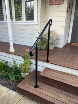 An elegant black handrail complements wooden steps, enhancing safety and accessibility.