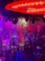 Eye-level view of aerial silk artist performing above a corporate event stage