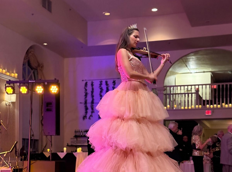 Elegant electric violinist performing in a glowing tower gown, creating a stunning aerial-style centerpiece for a luxury wedding or corporate event.