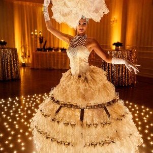 Luxury champagne service entertainment featuring elegant champagne hostesses in glamorous gold costumes serving guests at an upscale corporate event, creating an immersive and sophisticated reception experience.