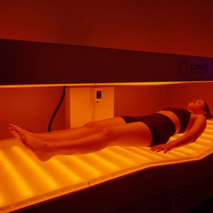 woman laying in red light therapy bed