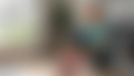 A woman in her 50s lacing up her running shoes in a bright living room.