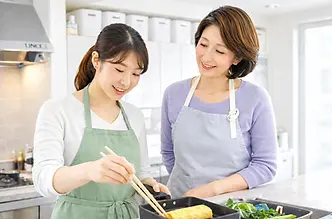 講師の指導のもと、出し巻き卵を作る生徒