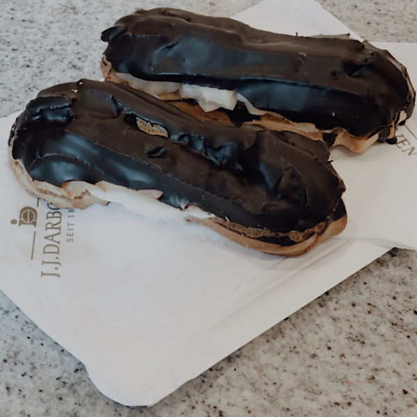 zwei Eclairs liegen auf einem Pappteller