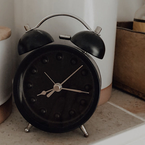 Schwarzer Wecker mit silbernen Zeigern. Uhrzeit 08:16 Uhr.