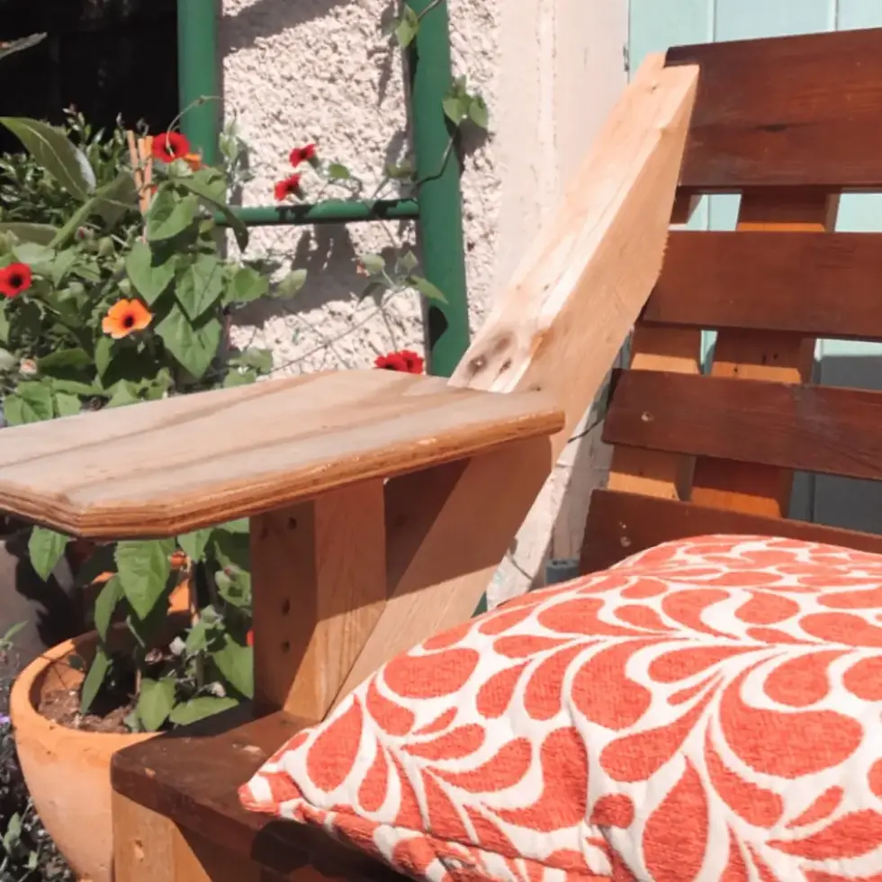 Sitzbank und range-weißes Sitzkissen im Garten