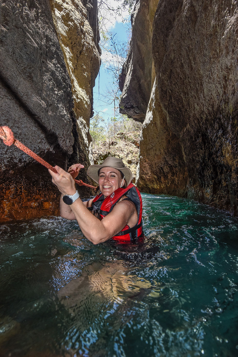 Visitors wearing life jackets and using the fixed rope to enter La Leona canyon