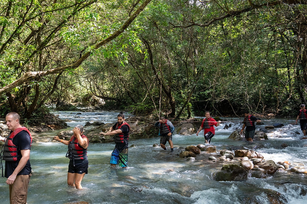 Visitors crossing the Río Blanco on the Regular La Leona Waterfall hike