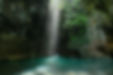 Sunlit La Leona Waterfall cascading into a teal pool