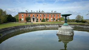 Edwardian building with reflective pond in foreground