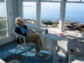 A woman sitting by the Maine coast
