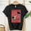 Thumbnail: Black short sleeve tee with red book cover of classic Mary Poppins illustration with Mary and her black umbrella