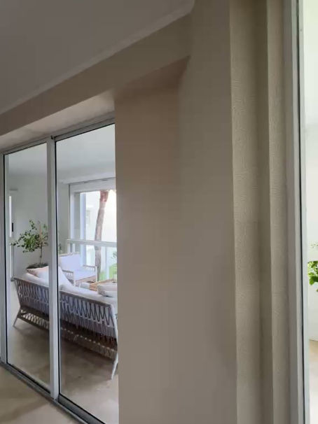 A detailed video walkthrough of an Ocean Ridge, FL living room featuring textured wallpaper TWC6646. The video showcases the organic pattern’s interaction with natural light and the precision of the installation around high-ceiling soffits and sliding glass door headers.
