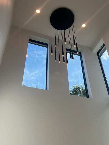 High-end vertical installation of TWC35172 designer wallpaper near me in a Delray Beach staircase, featuring a neutral linen texture on a non-woven backing.