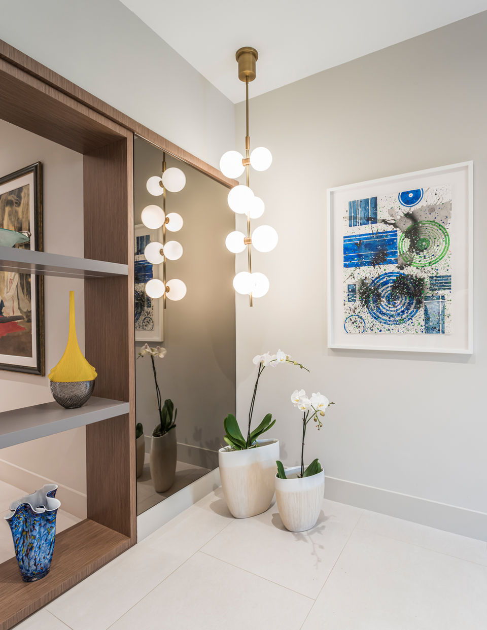 Modern entryway with chandelier, artwork, and plants