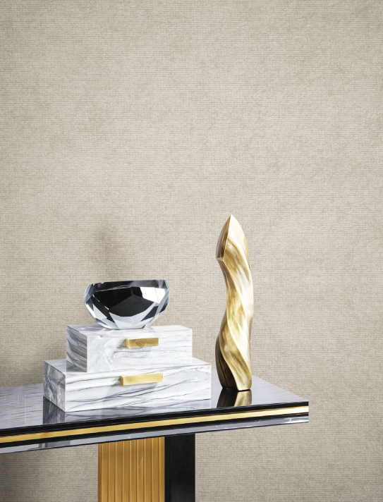 Marble and gold sculptures on a modern table with a beige textured wall. The scene is minimal and elegant, highlighting luxury decor.